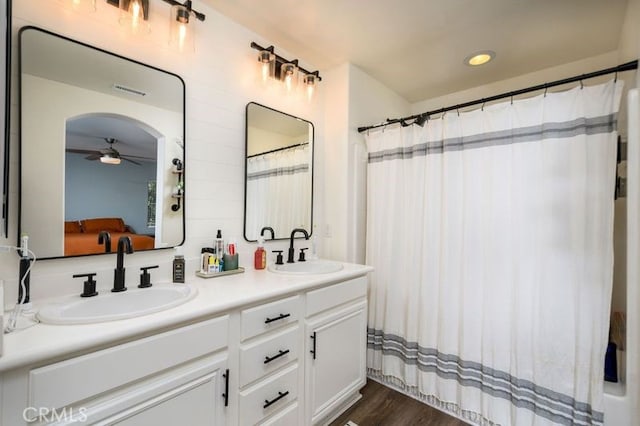 bathroom with tasteful backsplash, vanity, hardwood / wood-style flooring, and ceiling fan