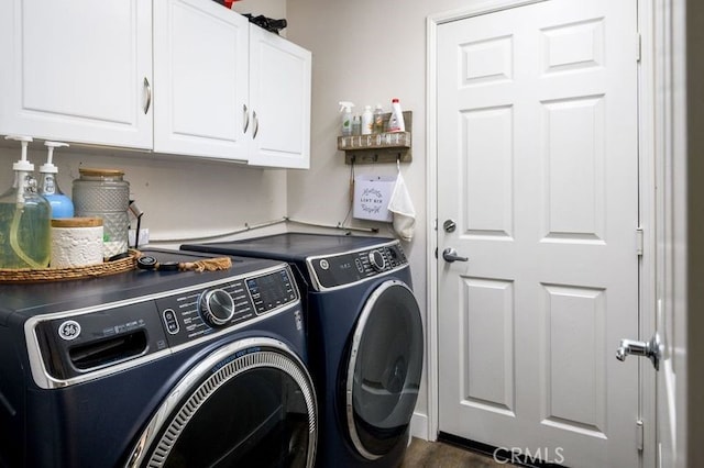 washroom featuring dark hardwood / wood-style floors, cabinets, and washing machine and clothes dryer