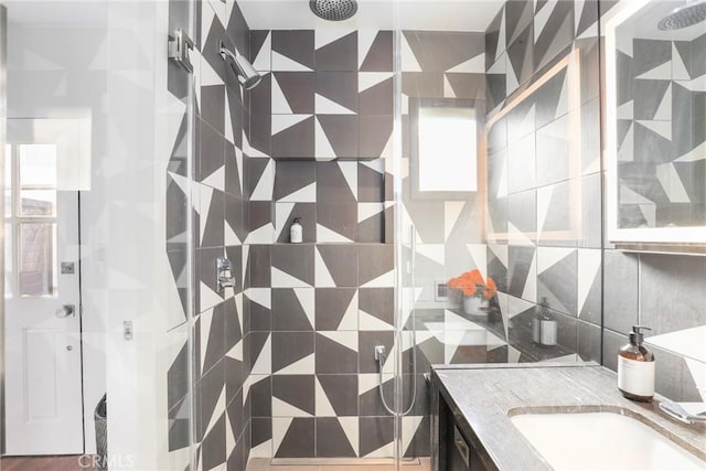 bathroom featuring a shower, vanity, and tile walls