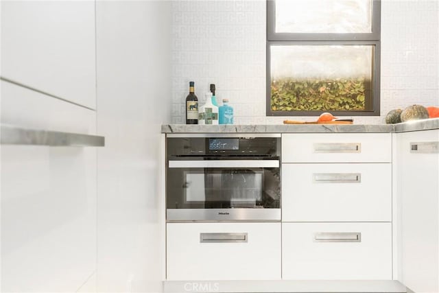 bar with stainless steel oven and white cabinetry