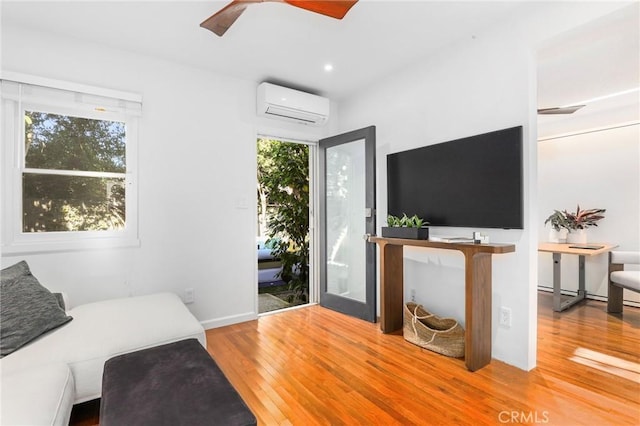 living room featuring a wall mounted AC, ceiling fan, and hardwood / wood-style flooring