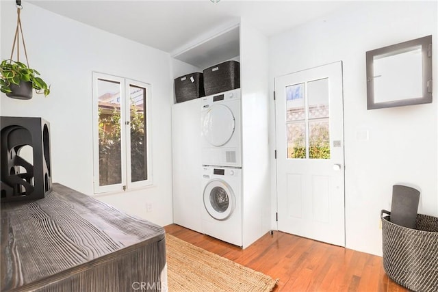 laundry area featuring hardwood / wood-style floors and stacked washer / dryer