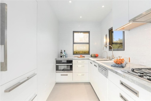 kitchen featuring backsplash, a wealth of natural light, white cabinets, and stainless steel appliances