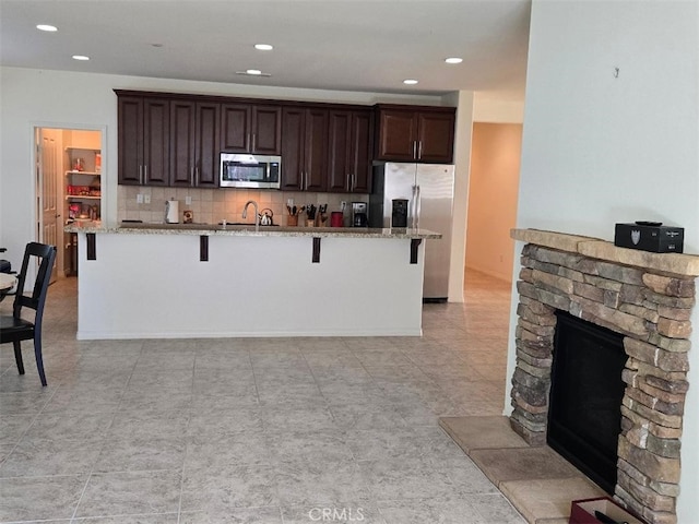 kitchen featuring sink, stainless steel appliances, a breakfast bar area, and an island with sink