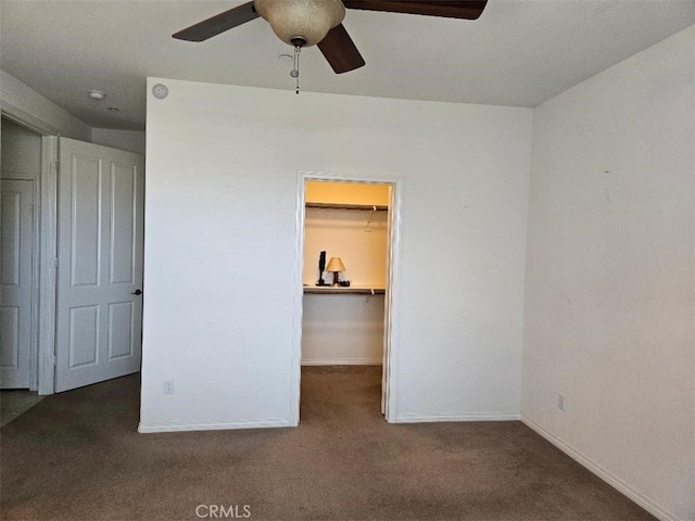 unfurnished bedroom featuring carpet floors, a spacious closet, a closet, and ceiling fan