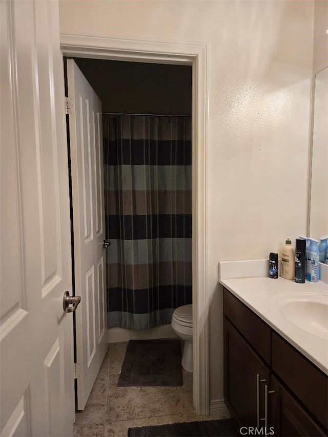 bathroom featuring vanity, a shower with shower curtain, and toilet