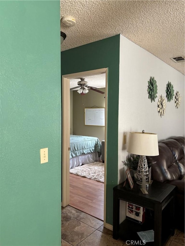 hall with wood-type flooring and a textured ceiling