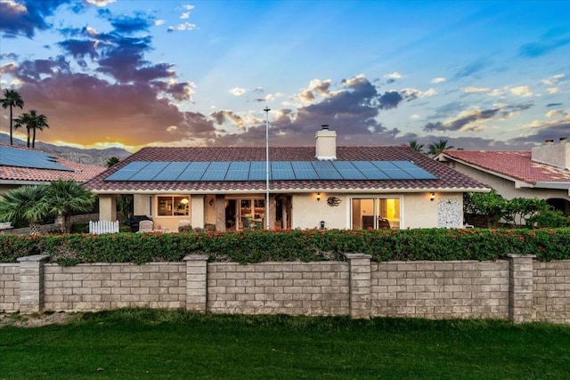 back house at dusk featuring solar panels