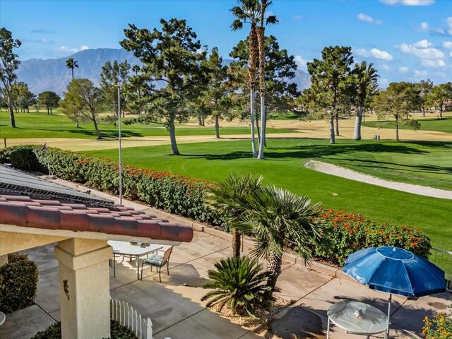 surrounding community with a mountain view, a yard, and a patio