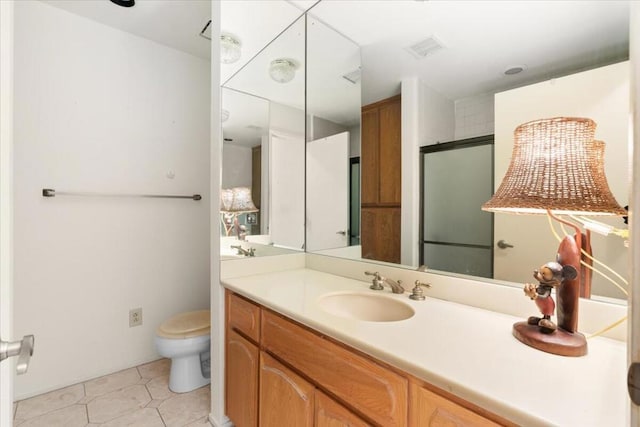 bathroom featuring tile patterned floors, vanity, a shower with shower door, and toilet