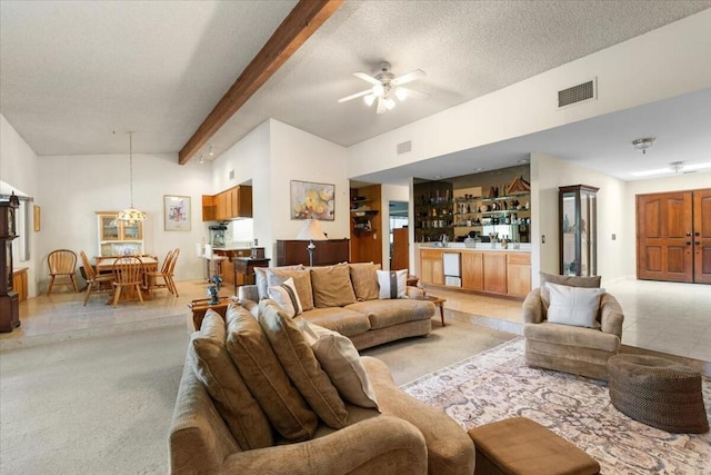 living room with beam ceiling, ceiling fan, high vaulted ceiling, light colored carpet, and a textured ceiling