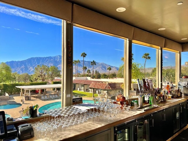 sunroom / solarium featuring a mountain view, beverage cooler, and bar