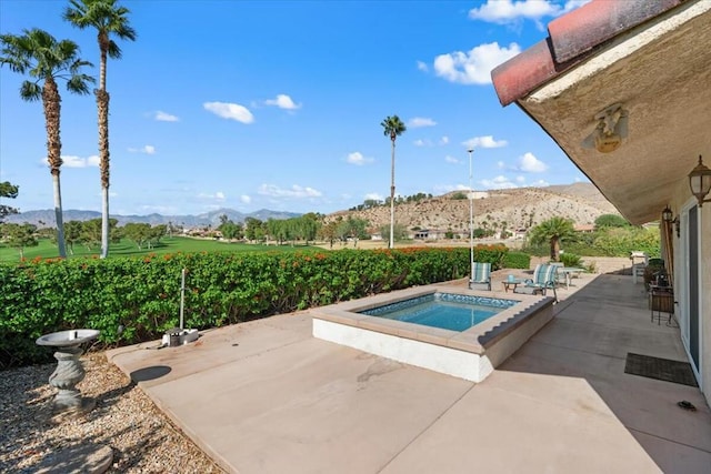 view of swimming pool with a mountain view, a patio, and an in ground hot tub