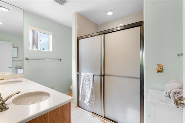 bathroom with tile patterned flooring, vanity, an enclosed shower, and toilet