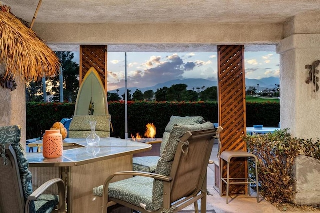 patio terrace at dusk with a mountain view and a bar