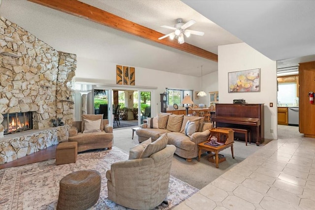 living room with beam ceiling, a stone fireplace, plenty of natural light, and ceiling fan