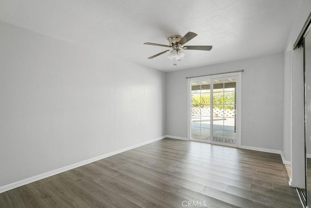 unfurnished room featuring ceiling fan and dark wood-type flooring