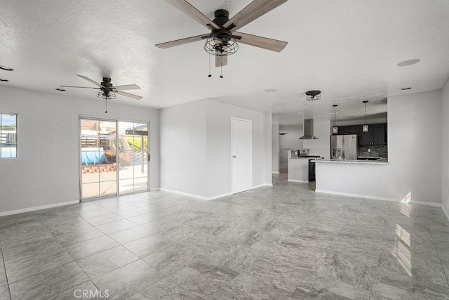 unfurnished living room featuring a textured ceiling and ceiling fan