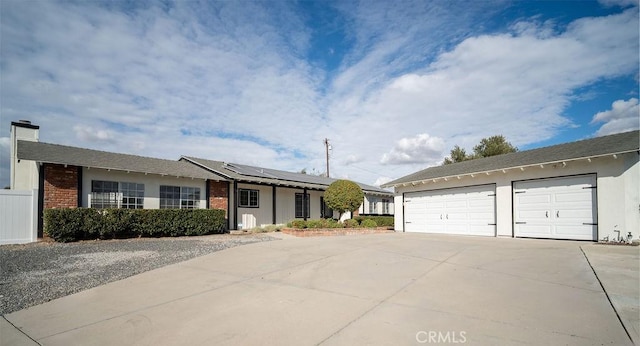 ranch-style house featuring solar panels and a garage