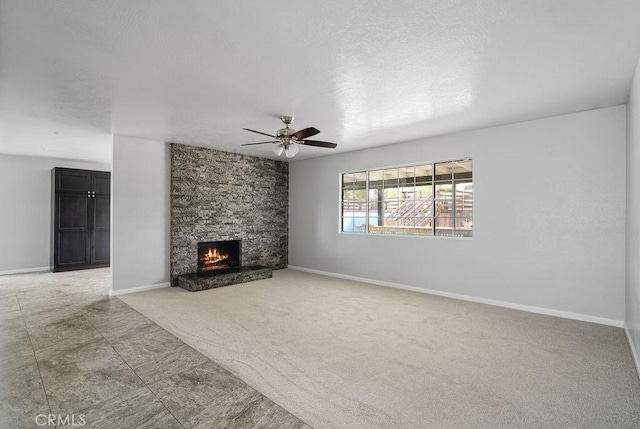 unfurnished living room with ceiling fan, carpet floors, and a fireplace