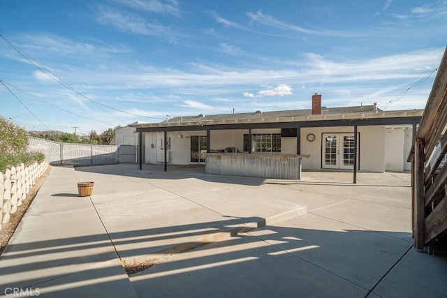 back of property featuring a patio area, french doors, and exterior bar