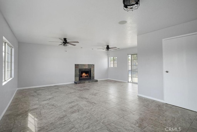 unfurnished living room featuring ceiling fan and a fireplace