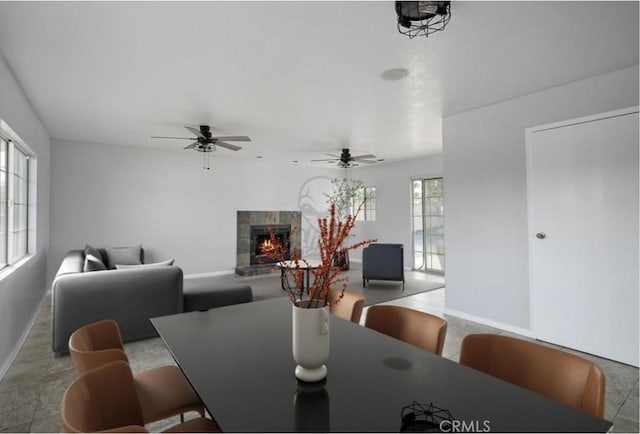 dining room featuring a tile fireplace and ceiling fan