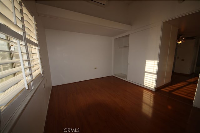 empty room with ceiling fan and dark hardwood / wood-style flooring