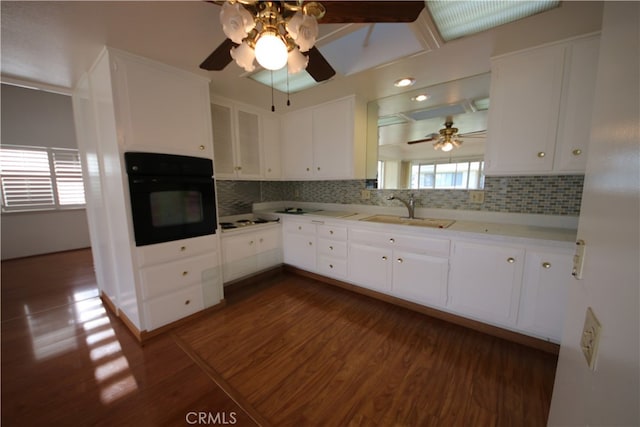 kitchen with sink, white cabinets, and black oven