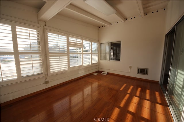 unfurnished sunroom featuring beamed ceiling and plenty of natural light