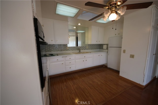 kitchen featuring dark hardwood / wood-style floors, backsplash, sink, white refrigerator, and white cabinets