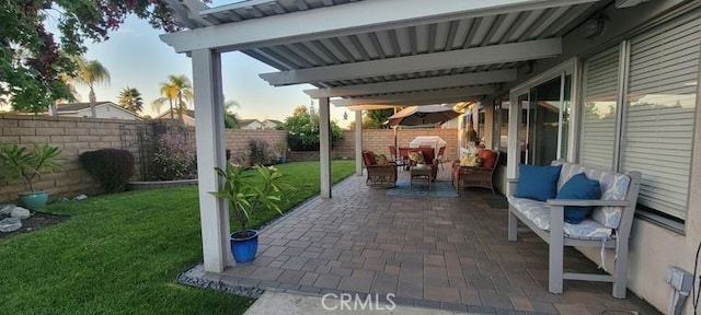 patio terrace at dusk with a lawn and outdoor lounge area