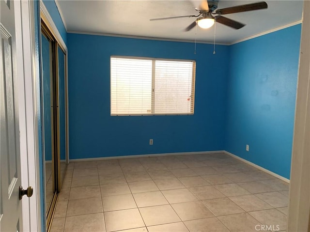 spare room with light tile patterned floors, ceiling fan, and ornamental molding