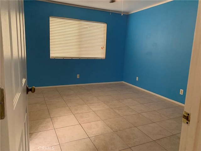 tiled empty room featuring crown molding