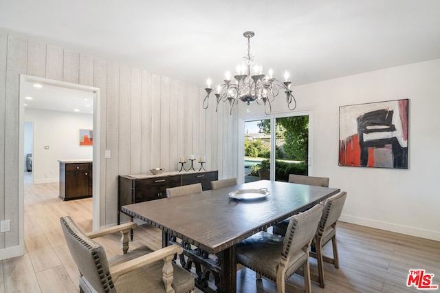 dining room with light hardwood / wood-style floors and an inviting chandelier