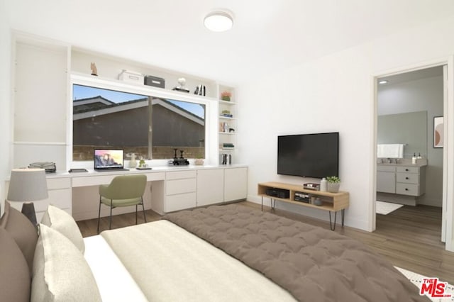 bedroom with hardwood / wood-style flooring, lofted ceiling, built in desk, and ensuite bath