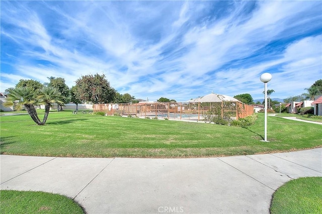 surrounding community with a lawn and a swimming pool