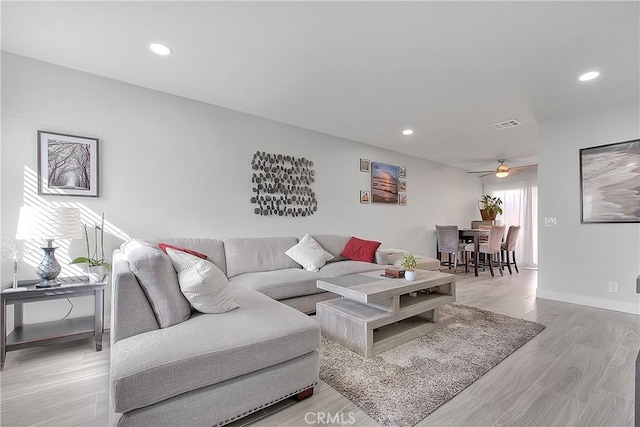 living room featuring ceiling fan and light hardwood / wood-style flooring