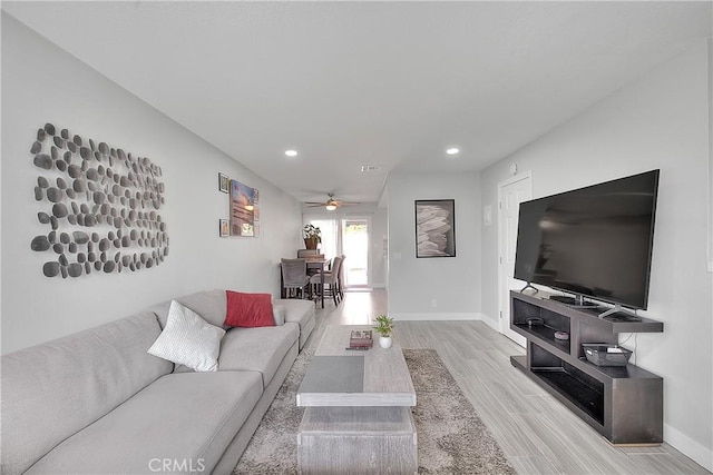 living room with ceiling fan and light wood-type flooring