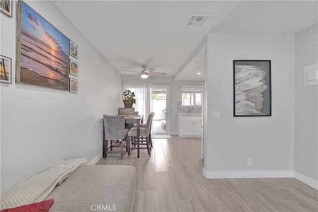 dining area with ceiling fan and light hardwood / wood-style flooring