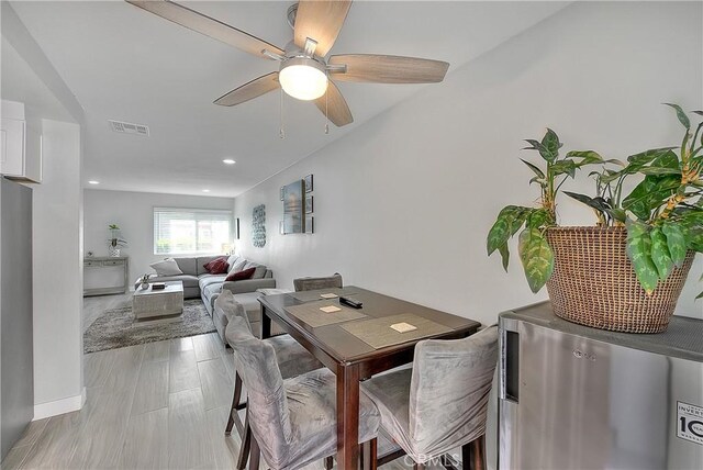 dining space featuring ceiling fan and light wood-type flooring