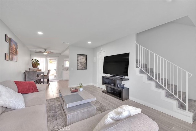 living room featuring wood-type flooring and ceiling fan