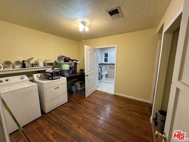 laundry area with dark hardwood / wood-style flooring, a textured ceiling, and washing machine and clothes dryer