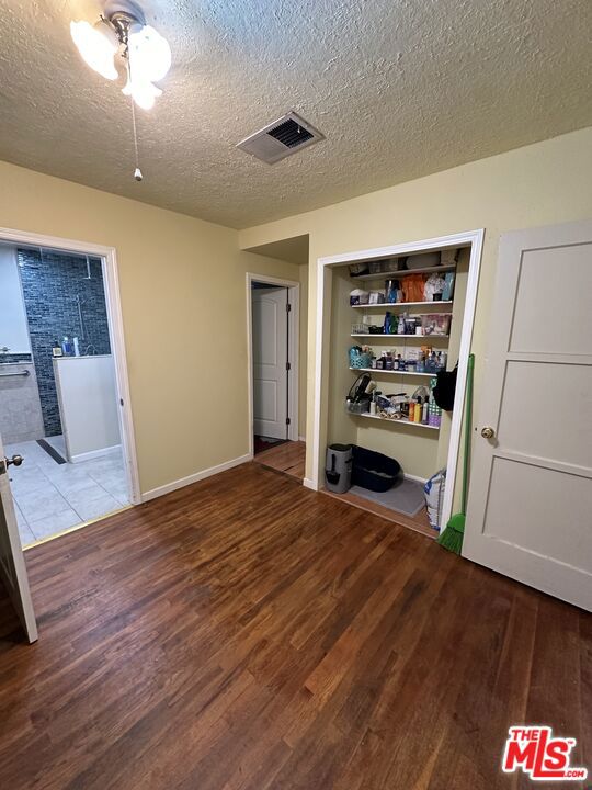 unfurnished bedroom featuring ceiling fan, light hardwood / wood-style flooring, and a textured ceiling