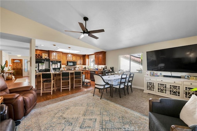 living room featuring hardwood / wood-style flooring, ceiling fan, and vaulted ceiling