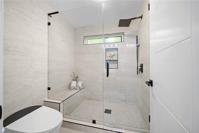 full bathroom with a stall shower, tile walls, and toilet