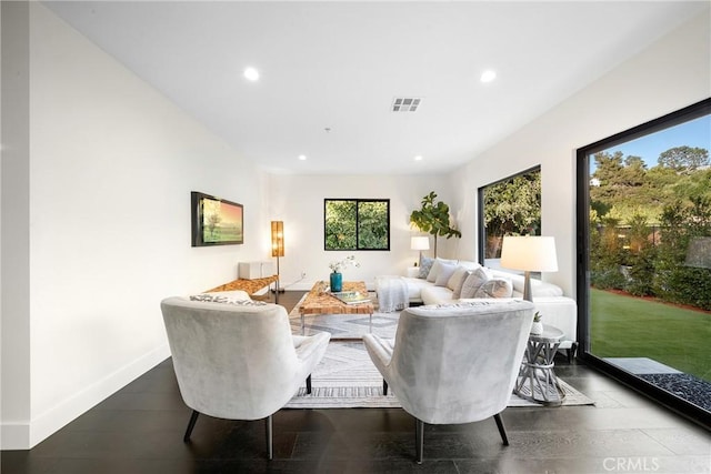 living area featuring baseboards, wood finished floors, visible vents, and recessed lighting