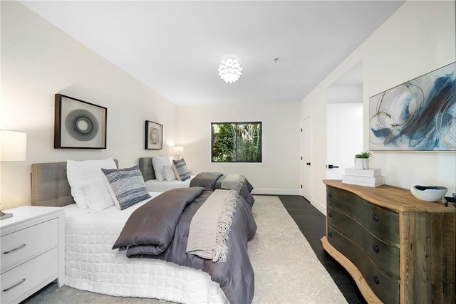 bedroom with baseboards and wood finished floors