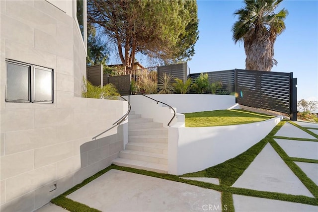 view of yard featuring fence and stairs