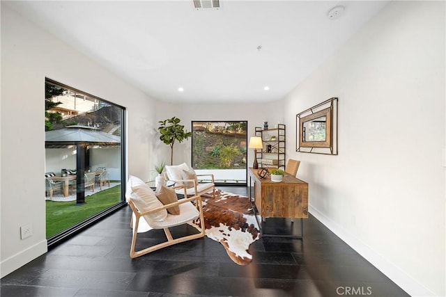 sitting room with recessed lighting, plenty of natural light, wood finished floors, and baseboards